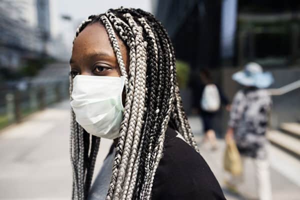 Femme enceinte portant un masque dans la rue pour se portéger de la pollution routière