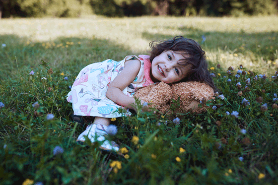 Petite fille Mila allongée sur l'herbe