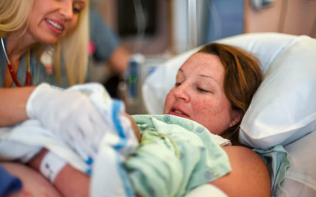 Femme recevant son bébé après avoir accouché, en salle d'accouchement
